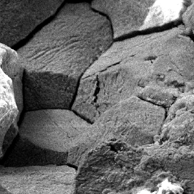 Intergranular morphology inside the pitting and evidences of chemical attack (dissolution).