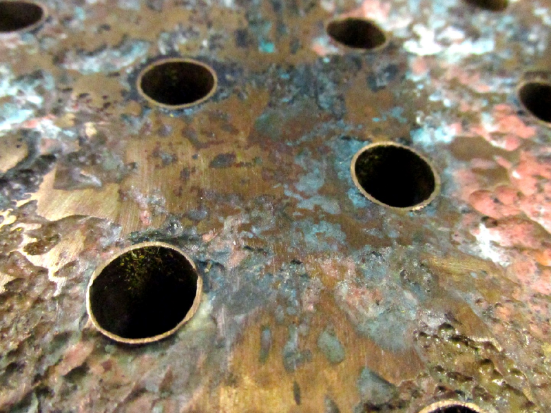 Aspect of the CuZn platesheet where it is corroded (cooling medium side).  The (hot) air cooler uses treated seawater as the cooling medium and the corroded regions are associated to the regions in the heat exchanger of higher temperatures, and the leakage occurred in regions of contact of the platesheet to cooper alloy tubes.