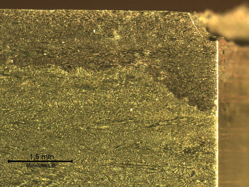 Macrographic detail of the transverse section of the tubesheet at the cooper alloy tube position, after removal of the 5/8" tube. The "layer" at the top of the plate (exposed to the cooling medium - treated seawater) is a region of selective corrosion, dezincification. It is possible to see that in the right side of the figure, where the cooper tube was positioned, the corrosion damage is deeper.