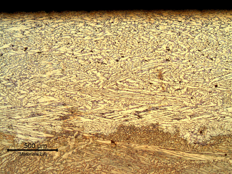 Same region of the previous figure, after etching. Micrography presenting the interface between the layer where the dezincification occurred (top of the figure) and the region where the material was not yet corroded (bottom of the figure, now etched to reveal the microstructure).