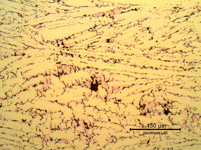 Micrography of the corroded region of the tubesheet presenting a microstructure of alpha (light yellow ), but no longer beta. In the position of the beta phase it is possible to see the cooper rich island (light red) and cracks (black) due to the selective removal of the zinc.