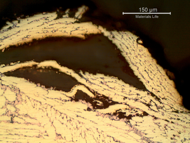 Micrography showing detachment of material at the surface of the platesheet. The cracks are associated to the dezincification effect, where the beta phase was preferentially corroded and became a weak porous layer.
