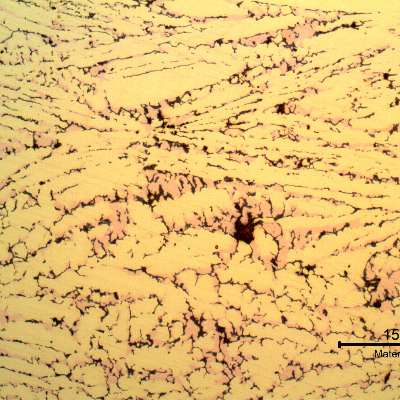 Micrography of the corroded region of the tubesheet presenting a microstructure of alpha (light yellow ), but no longer beta. In the position of the beta phase it is possible to see the cooper rich island (light red) and cracks (black) due to the selective removal of the zinc.