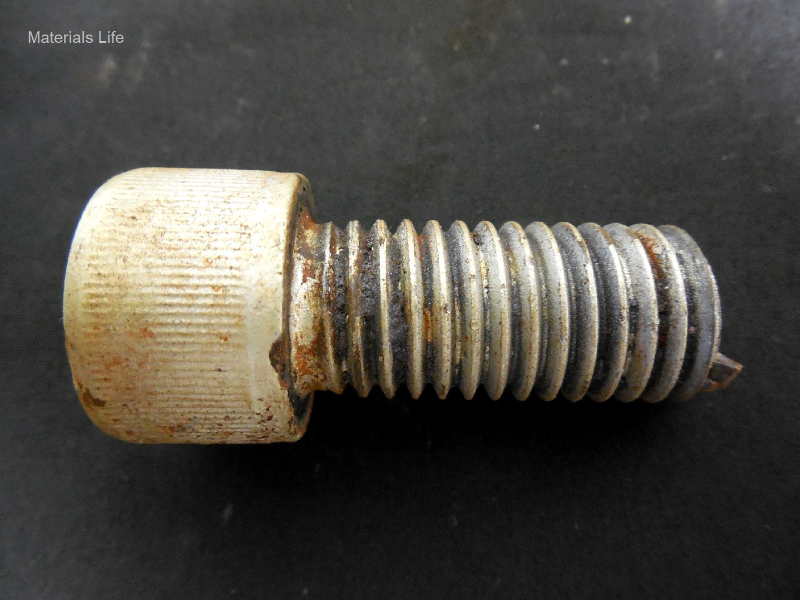 Aspect of the broken bolt, 5/8" Allen, socket head cap screw, originally 1 3/4" long, broken in subsea service under cathodic protection. The bolt presents a zinc coating.