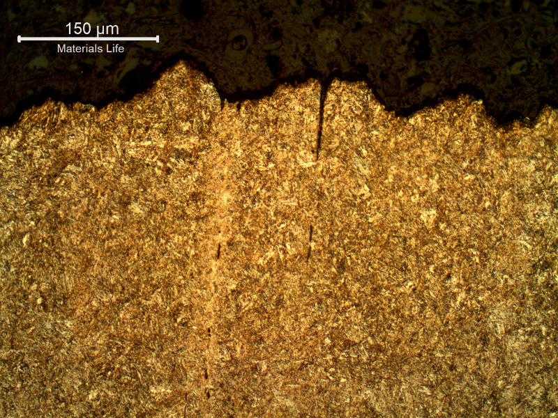 Micrography of the longitudinal section of the bolt, in the center of the thickness, showing at the fracture surface (top of the figure), secondary cracks that are perpendicular to the fracture, associated to segregation bands.