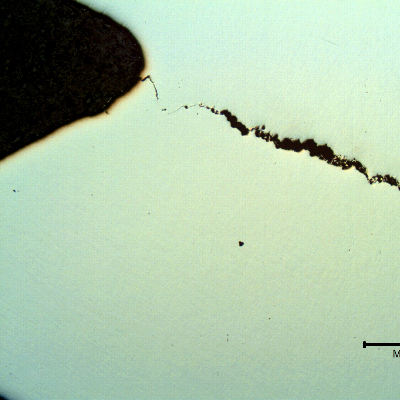 Micrography of the longitudinal section of the stud showing internal cracks, secondary (not the cracks that opened the fracture).  It is evident that the cracking from the thread fillet, of a ductile aspect, presented a different aspect than the internal cracks, of a brittle aspect.
