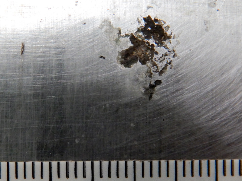 Aspect of the hydraulic cylinder surface presenting white stains and black oxides in a region that started a localized dissolution under deposit.