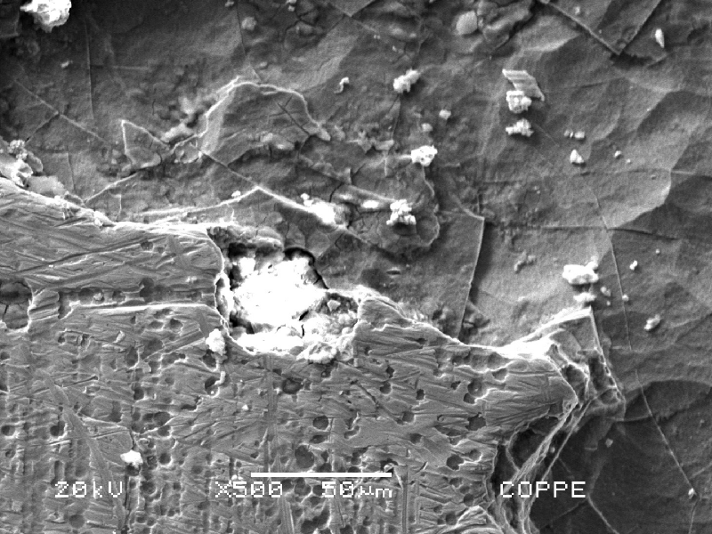 Scanning electron microscopy image of the chromium plated cylinder in a region of localized dissolution under deposit. Inside the shallow pitting the Cr structure with a network of layers is revealed by the etching effect promoted by microbiollogically induced corrosion.