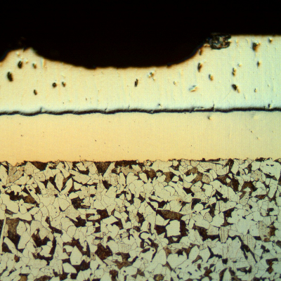 Micrographic detail of the longitudinal section of the cylinder, at the surface, in a region where the Cr layer is detaching.