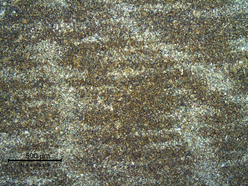 Micrography of the base metal, in low magnification, showing regions of segregations in a quenched and tempered martensitic structure.