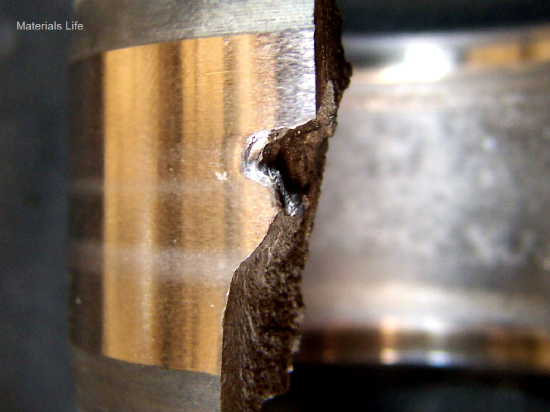 Aspect of the external surface of the broken cylindrical roller bearing presenting a polished external diameter and a the rupture with brittle characteristics (flat and parts that were lost).