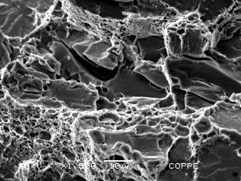 Aspect of the roller bearing fracture surface, by scanning electron microscopy, close to the internal surface.  In this position the fracture shows ductile micromechanisms (dimples) as well as decohesion of large carbides and (brittle) cleavage facets, typical of overloading this low strenght, and low toughness, ferritic structure (21 HRc).  The structure in this region, ferritic with large broken carbides and small rounded carbides, is of a low toughness, as indicated by the fracture.