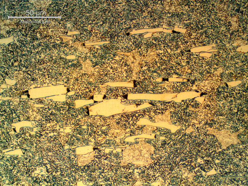 Micrographic detail of the roller bearing microstructure, close to the internal surface, presenting 21 HRc and a microstructure that is ferritic with large carbides (cracked) and small round carbides.