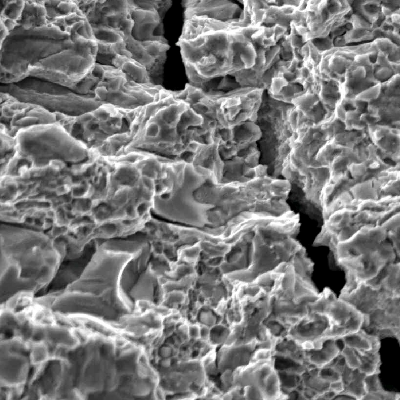 Fractography of the roller bearing, close to the external surface.  In this position the fracture of the cylindrical roller bearing shows micromechanisms of decohesion at large carbides (cracked) and quasecleavage, typical of overloading this high strength tool steel (martensitic with  carbides at 64 HRc).