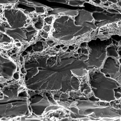 Fracture micromechanism at a region close to the internal surface.  In this position the fracture shows ductile micromechanisms (dimples) as well as decohesion of large carbides and (brittle) cleavage facets, typical of overloading this low strenght ferritic structure (21 HRc).  The structure in this region, ferritic with large broken carbides and small rounded carbides, is of a low toughness, as indicated by the fracture.