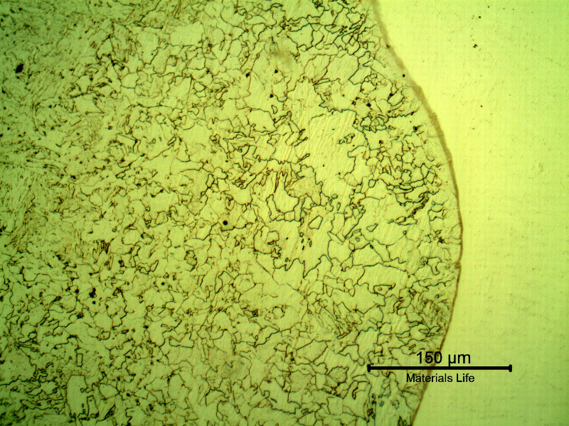 Micrography of a longitudinal section of the pipe at the overlay fusion line, with Nital etch that reveals only the low alloy steel structure, to the left side of the image.  Some decarburization of the low alloy steel substrate is evident since the microstructure is slightly different a little far from the interface.