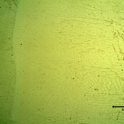 Low magnification micrography of a longitudinal section of the pipe at the interface between overlay layers, with electrolytic etch that reveals the Ni alloy structure, large columnar grains with celular morphology.