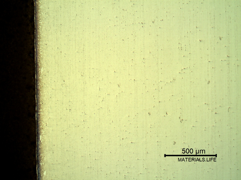 Micrography of a longitudinal section of the pipe at the interface,with oxalic acid electrolytic method that overetchs the low alloy steel structure (to the left side of the image), and reveals the structure of the clad plate interface, different at the position where it was metallurgically bonded to the the pipe (when it was still a low alloy plate - X65).
