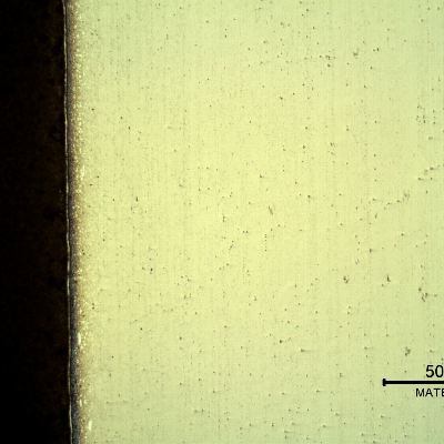 Micrography of a longitudinal section of the pipe at the interface,with oxalic acid electrolytic method that overetchs the low alloy steel structure (to the left side of the image), and reveals the structure of the clad plate interface, different at the position where it was metallurgically bonded to the the pipe (when it was still a low alloy plate - X65).