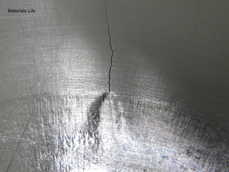 Image of the external surface of the valve body at the region where the Alloy 625 insert was fillet weld to the SDSS valve body. The surface was later machined, so it is possible to see only a mark indicating where the weld is. The brittle crack is arrested at the margin of the weld. It is possible to see strong deformation at the crack tip when it arrives the weld.