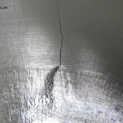 Image of the external surface of the valve body at the region where the Alloy 625 insert was fillet weld to the SDSS valve body. The surface was later machined, so it is possible to see only a mark indicating where the weld is. The brittle crack is arrested at the margin of the weld. It is possible to see strong deformation at the crack tip when it arrives the weld.