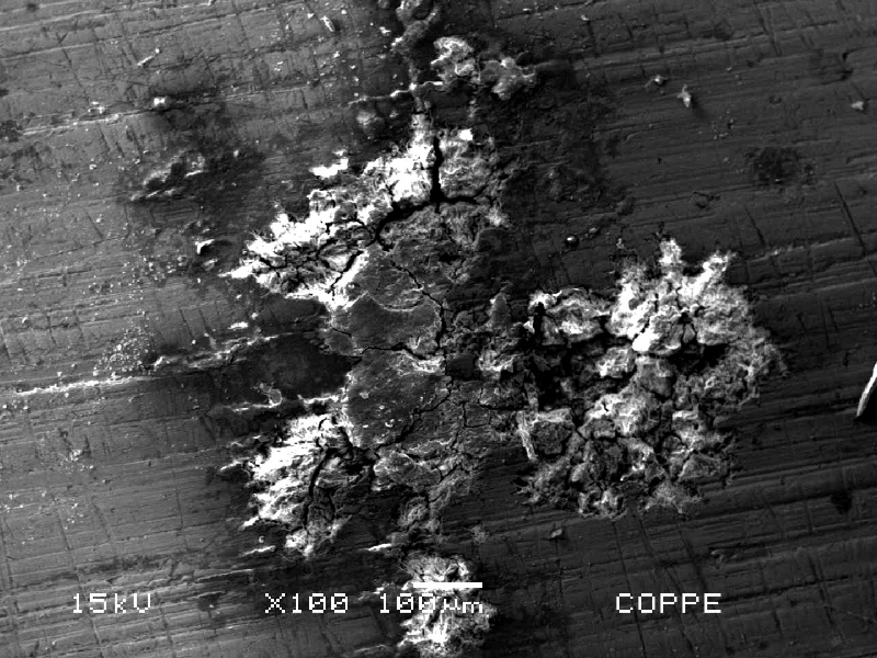 Microscopical aspect by scanning electron microscopy (SEM) of the external surface of a drilling tool in a position that presented localized deposits and corrosion under deposit. The deep corrosion in a short time is only possible associated to the biological growth and aggressive environment generated by the microorganisms metabolites - Microbiologically Induced Corrosion (MIC).