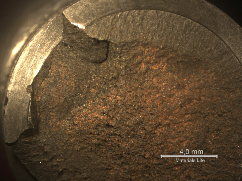 Macroscopic view of the fracture surface showing that there is a flat appearance of the fracture close to the bottom of the thread (upper side of the figure) and a flat, but rough appearance in the center of the stud. No evidences of corrosion in the thread fillets indicating that the stud was protected.
