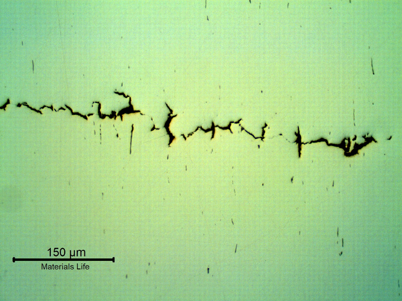 As polished micrography of the longitudinal section of the stud at the cracking transverse to the axis. It looks like inclusions/possible banding regions are contributing for the cracking.
