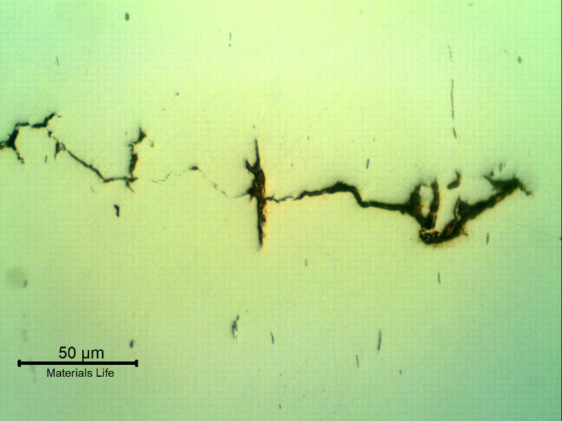 As polished micrography of the longitudinal section of the stud at the cracking transverse to the axis. It looks like inclusions/possible banding regions are contributing for the cracking.
