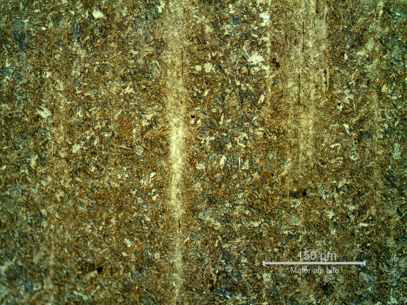 Microstructure of the stud in the longitudinal section, presenting segregated bands, not uniformly distributed in the section.  The bands are associated to elongated and aligned inclusions, and a refined microstructure, probably due to carbon and alloying elements concentration.
