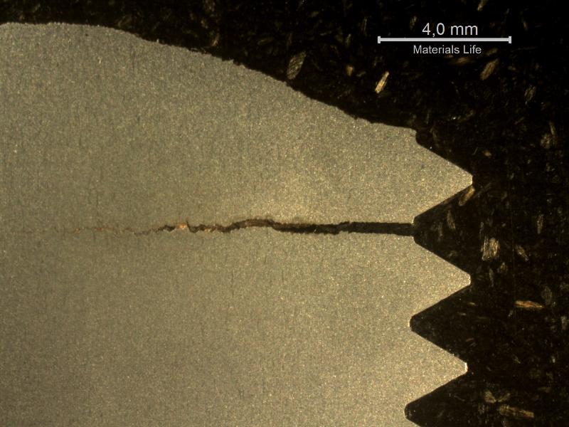 Macrography of a stud longitudinal sectiion at the fracture position (top of the figure). It is possible to see a large secondary crack at the bottom of the thread fillet adjacent to the fracture surface, without any deformation evidence.  This reveals a brittle material behavior, although the hardness measured at the stud end revealed 33HRc, as should be expected by the material specification.
