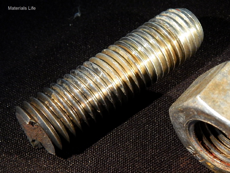 Aspect of the broken stud that was fastening a flanged line in a subsea body (tapped hole) using a nut.  The fracture, transverse to the stud axis, occurred exactly at the body to flange interface. Adjacent to the fracture, all thread fillets (positioned inside the flange hole) presented cracks at the bottom of the thread.  The stud was operating during seven years and was not corroded, indicating it was protected by the anodes.  There are also deposits in the fillets suggesting the cathodic protection was effective even inside the flange hole.