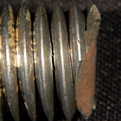 Macroscopic detail of the stud, adjacent to the fracture, showing that there are several secondary cracks at the bottom of the thread fillets, without any deformation evidence.  This reveals a brittle material behavior, although the hardness measured at the stud end revealed 33HRc, as should be expected by the material specification.
