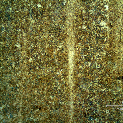 Microstructure of the stud in the longitudinal section, presenting segregated bands, not uniformly distributed in the section.  The bands are associated to elongated and aligned inclusions, and a refined microstructure, probably due to carbon and alloying elements concentration.