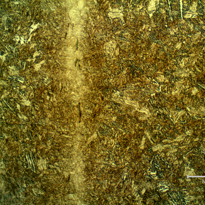 Micrographic detail of the segregated bands, not uniformly distributed in the section. The bands are associated to elongated and aligned inclusions, and a refined microstructure, probably due to carbon and alloying elements concentration.  The localized microhardness (50g) in the band  showed levels about 540HV, and out of the band, in the same localtion, presented an average hardness of 321 HV, indicating that the material is non uniform in the regions where there are bands.