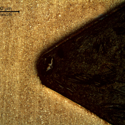 Longitudinal section micrography in a position of the thread, far from the failure. The stud presented a quenching and tempering structure and the thread was machined.