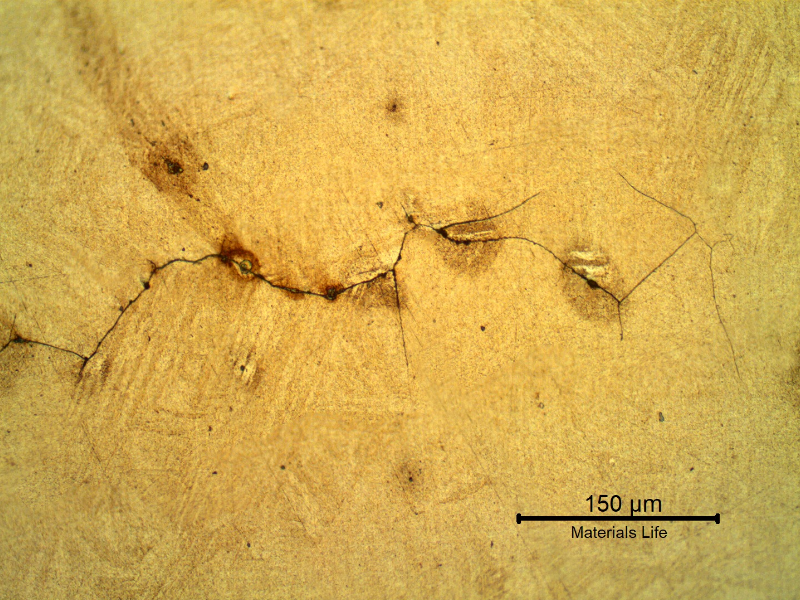 Micrography of a longitudinal section of the spring indicating that under the deposits there are intergranular cracks initiating at the spring surface.