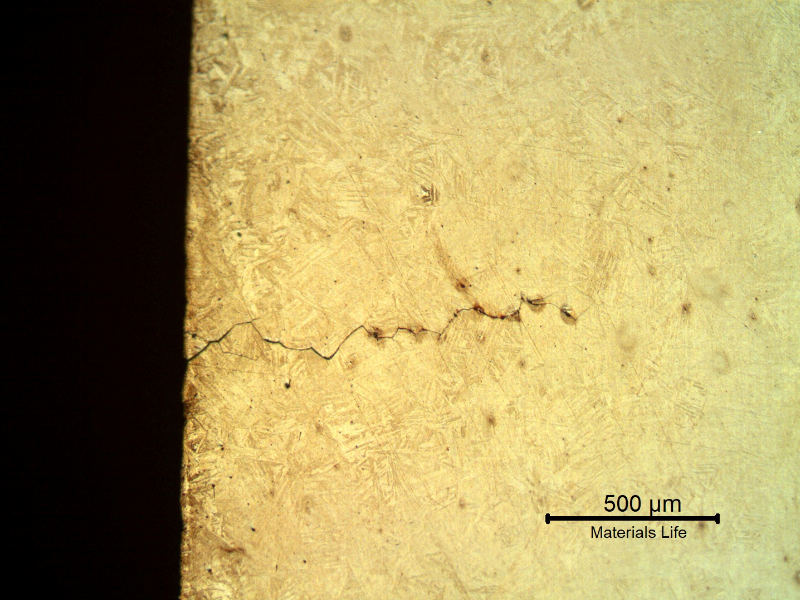 Micrographic detail of a longitudinal section of the spring indicating that under the deposits there are intergranular cracks initiating at the spring surface.