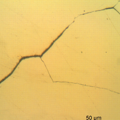 Micrographic detail of a longitudinal section of the spring indicating that under the deposits there are intergranular cracks initiating at the spring surface.