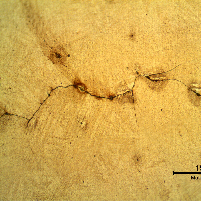 Micrography of a longitudinal section of the spring indicating that under the deposits there are intergranular cracks initiating at the spring surface.