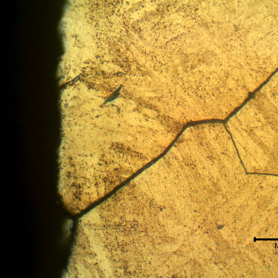 Micrographic detail of a longitudinal section of the spring indicating that under the deposits there are intergranular cracks initiating at the spring surface.