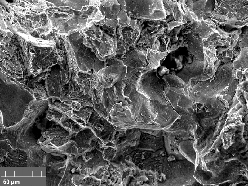 Scanning electron fractography (originally 1000x), showing intergranular aspects in the fracture surface.