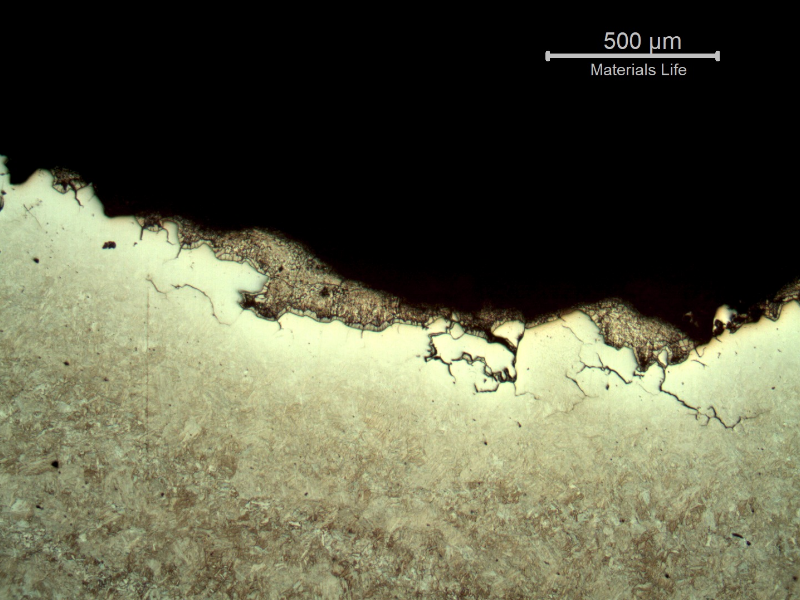 Micrography of the section transverse to the fracture (top of the figure). The fracture is intergranular, there are several secondary cracks, and there are deposits of zinc over the fracture.  The zinc makes difficult the etch with Nital to reveal the microstructure close to the fracture surface.