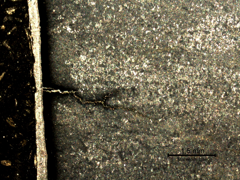 Macrographic detail of the branch cracks starting from the surface, parallel to the fracture.