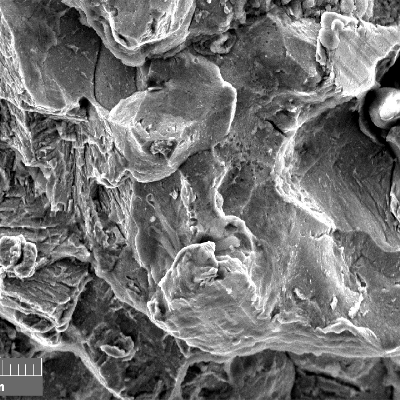 Scanning electron fractography (originally 2000x), showing intergranular aspects in the fracture surface.