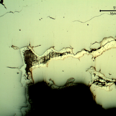 Micrographic detail of the branch cracking parallel to the fracture, as polished, showing that the cracks are filled with zinc.