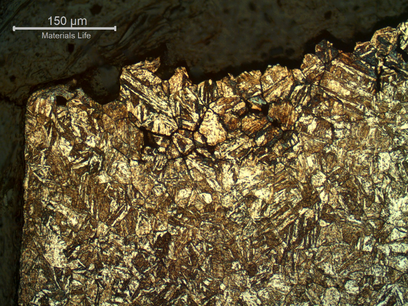 Micrography of a longitudinal section of the bolt, in a position close to the fracture (top) and bolt surface (left ), presenting several secondary intergranular cracks.  The structure is aged martensite and the cracks are located in the previous austenite grain boundaries.