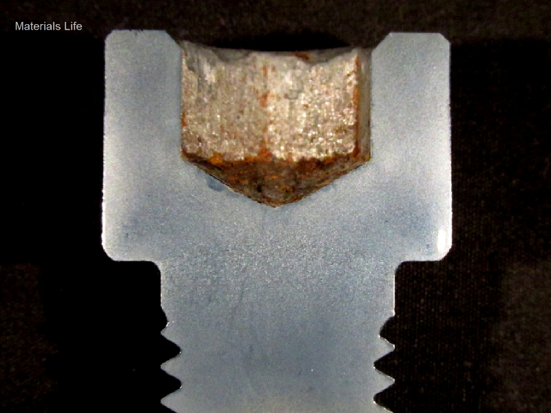 Macrography of the longidutinal section of a non broken allen bolt, at the threaded body to bolt head transition. The granular structure is different through the bolt, with refined structure in the threaded body and coarse at the transition.