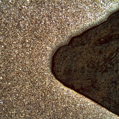 Micrography of a longitudinal section of the 5/8" bolt, at the bottom of the thread, presenting a refined structure compared to the center of the bolt and a mark at the thread flank that was probably created during tightening of the bolt.