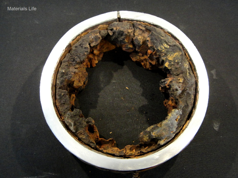 Aspect of a transverse section of the 4" pipe showing the barnacles adhered to the internal pipe surface, and the leakage position (in the top of the figure).  It is possible to see that the deposits are attached all throught the internal pipe perimeter but the damage is localized.  The damage morphology suggests it is a crack, or a welding defect, but the microstructural analysis indicated that the damage is a galvanic effect at the autogenous seam weld.